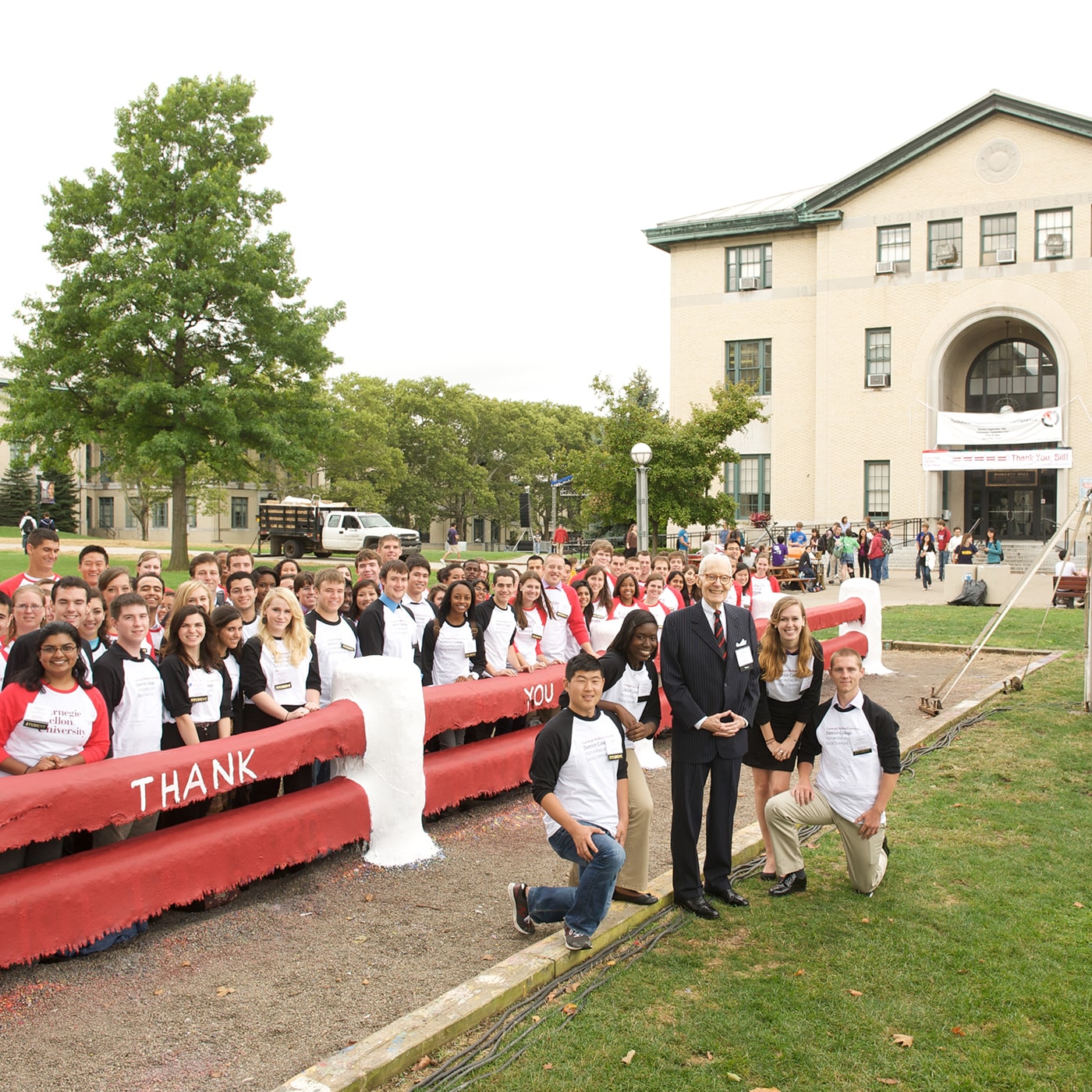 people standing on The Cut at red fence with thank you painted in white