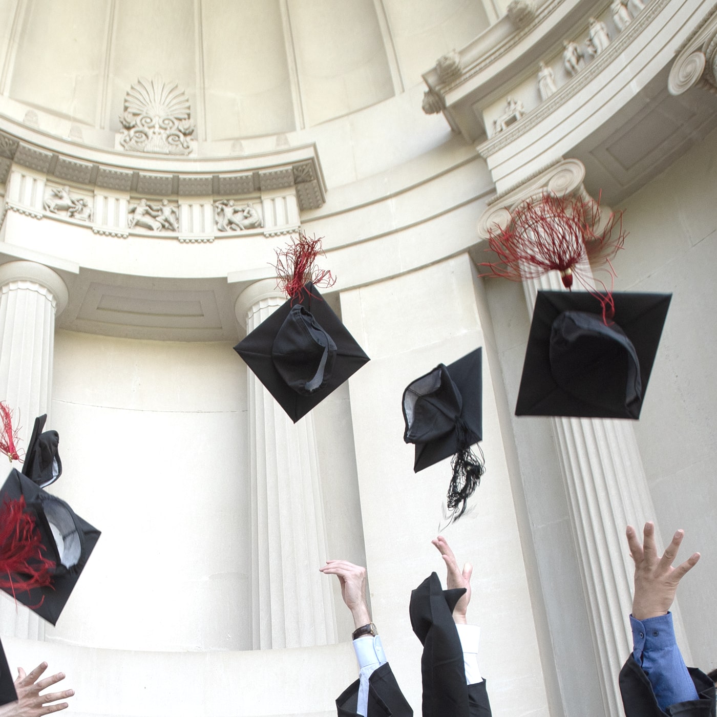 Students throw graduation caps into the air.