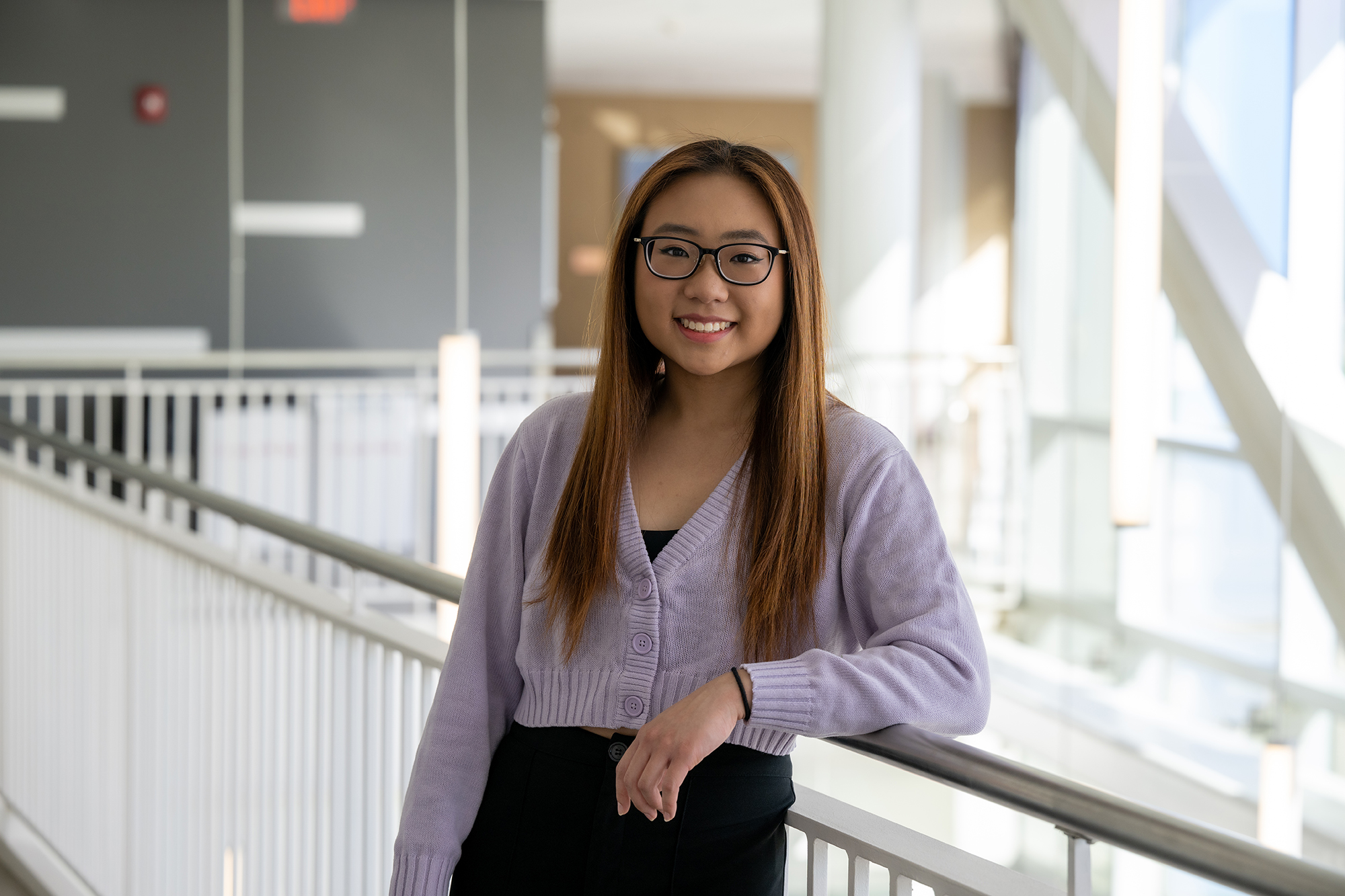 Lianna Huang leans against a railing and smiles at the camera