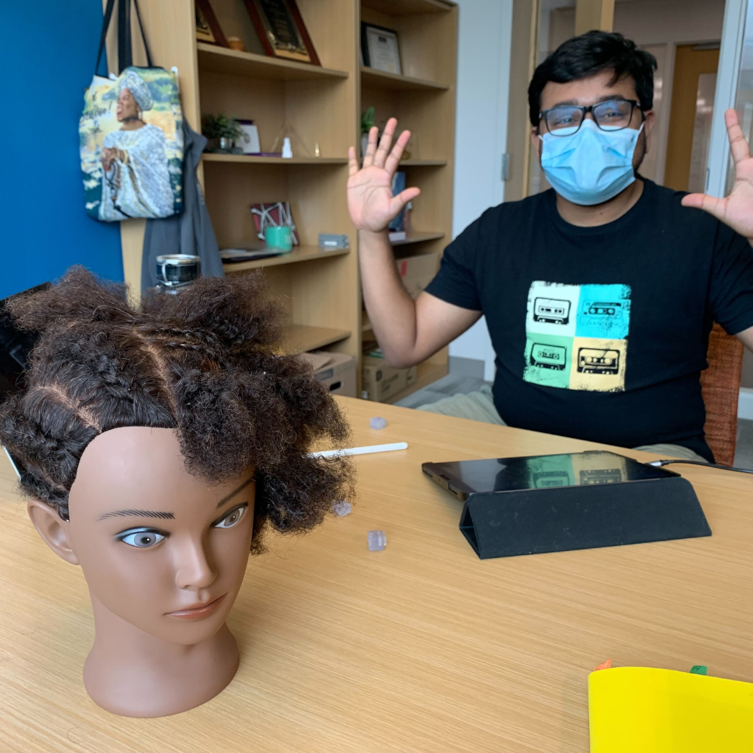 research-fellow-at-table-working-holding-hands-up