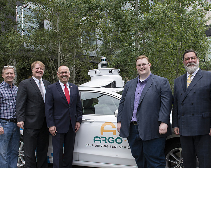 An image of CMU, Argo and Pittsburgh leadership in front of an autonomous vehicle