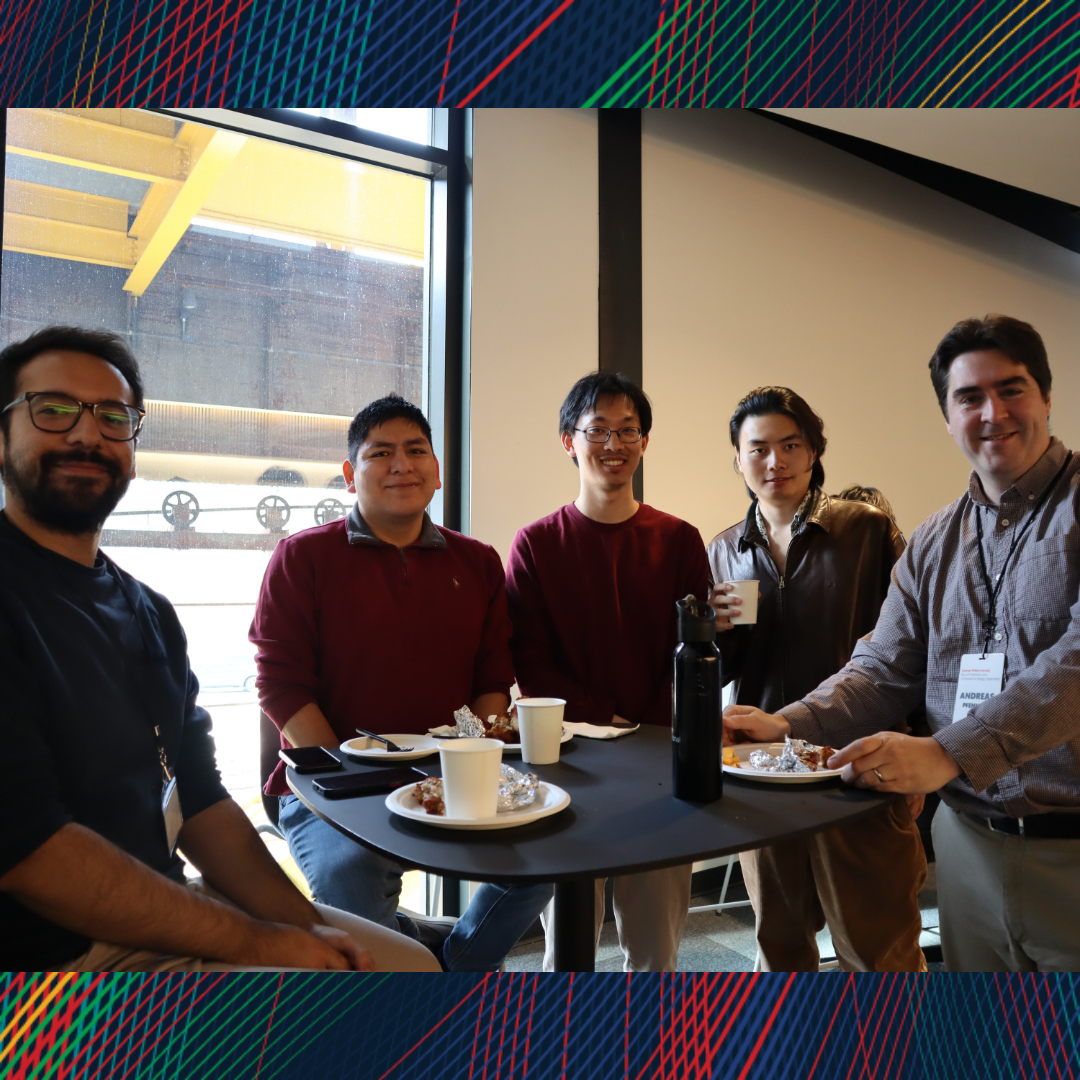A group of men smiling at the camera during lunch