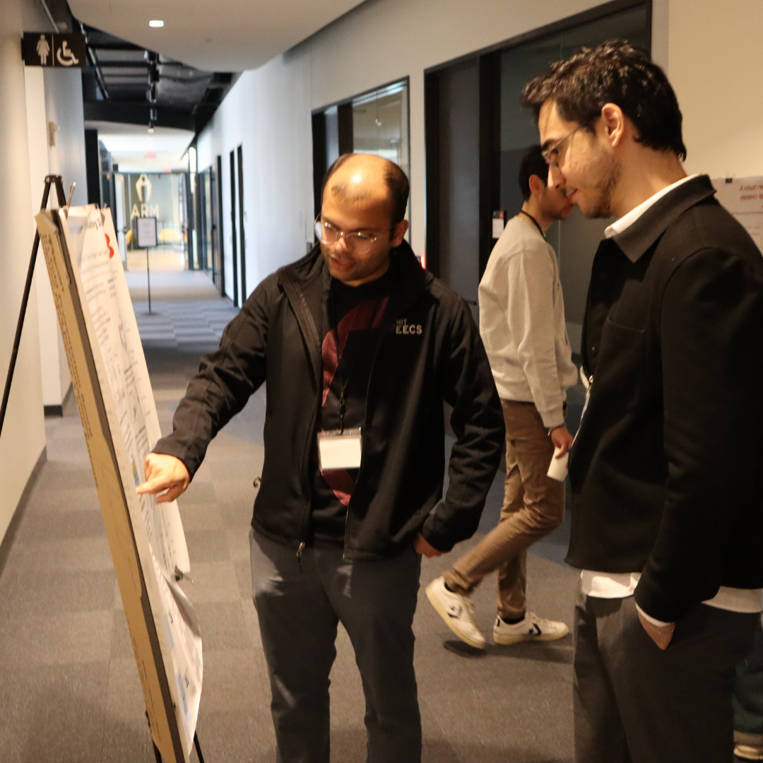 Two people discussing in front of a poster
