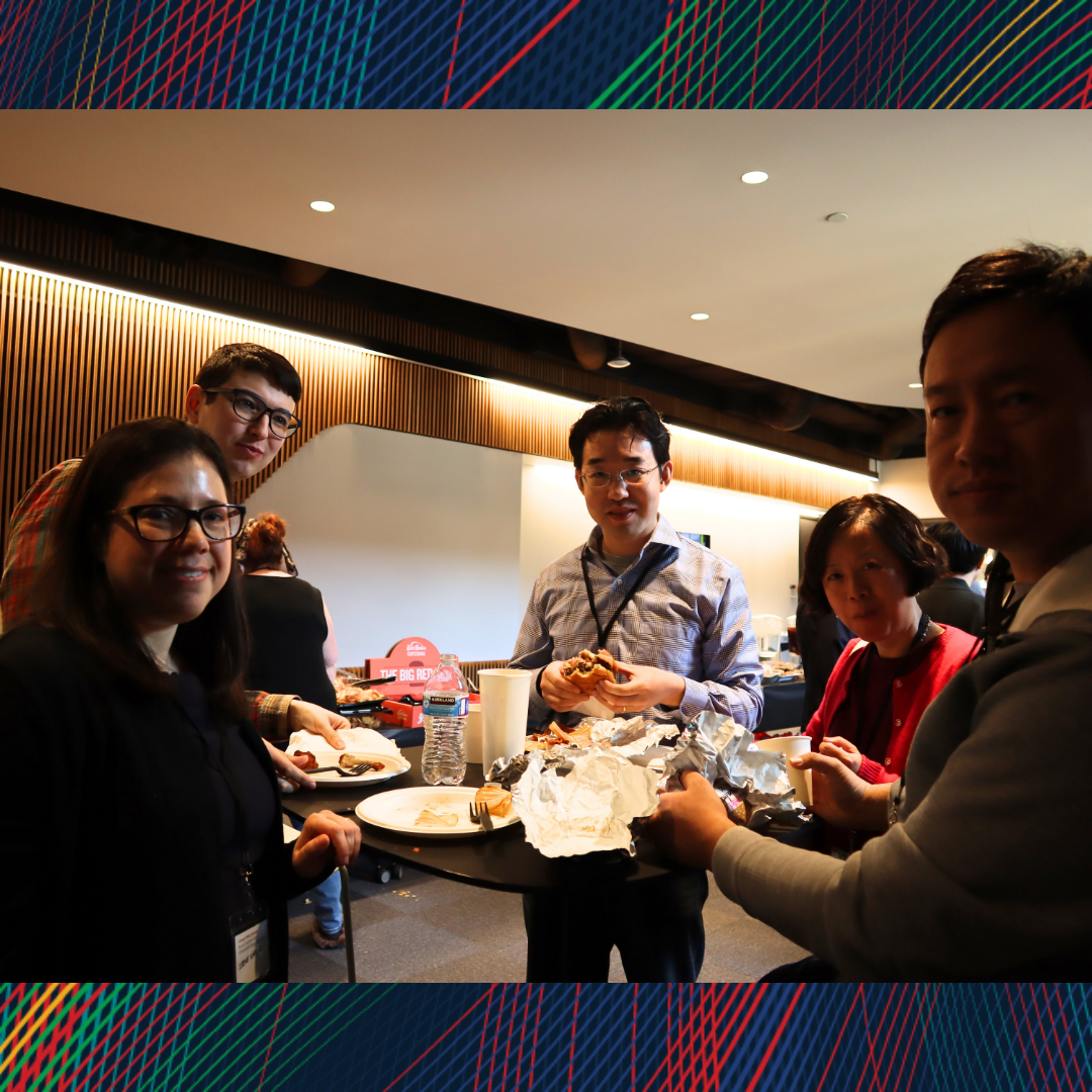 A group of people having lunch and smiling at the camera