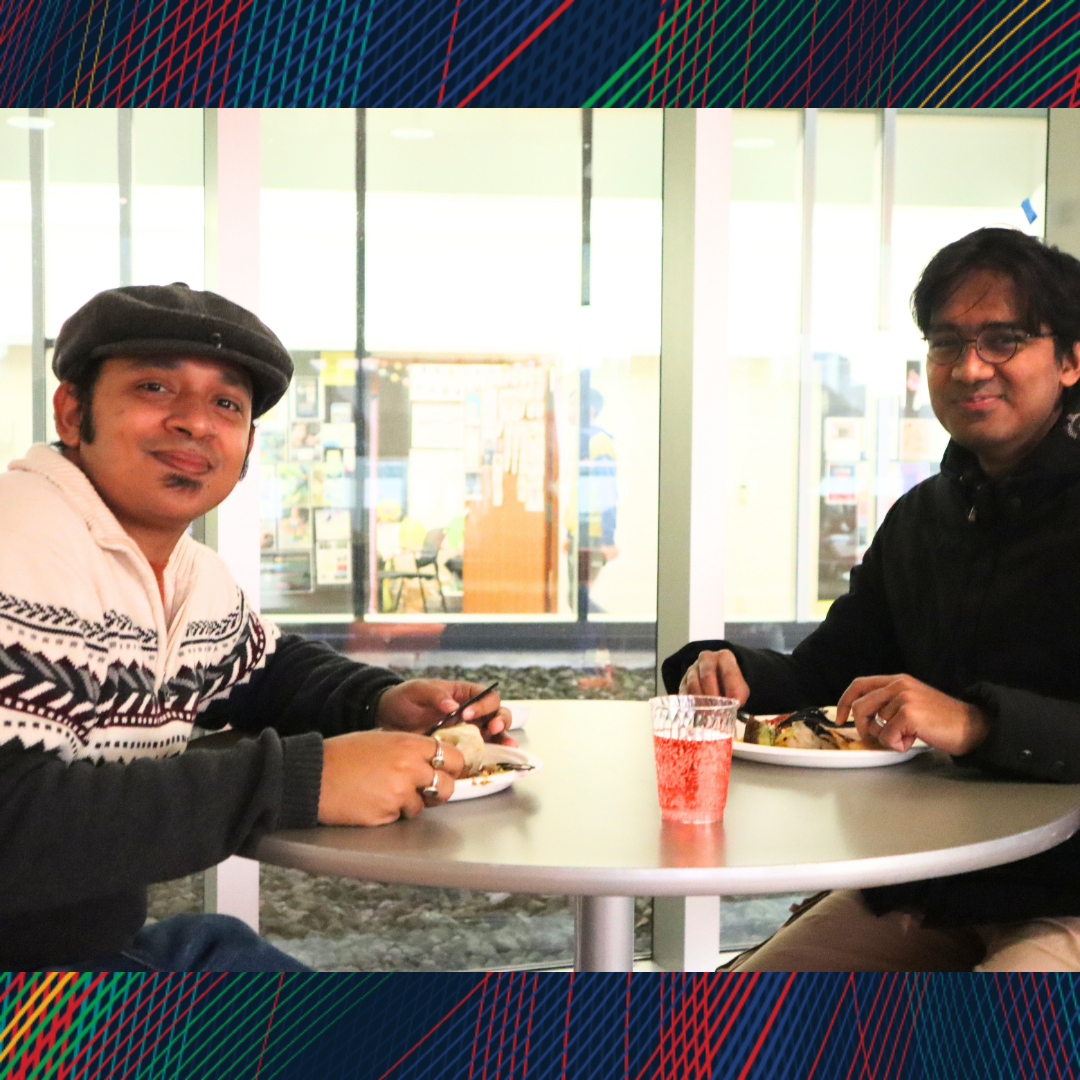 Two men having lunch and smiling at the camera