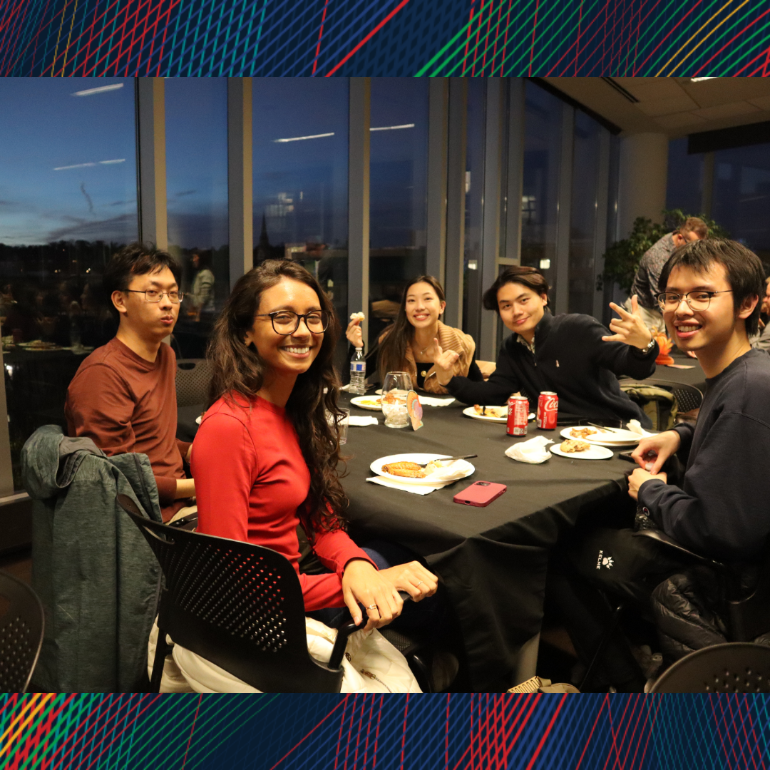 A group of people sitting at the table smiling at the camera