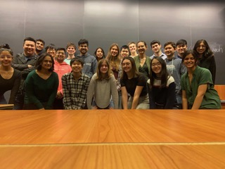 students standing in front of a black board in a class room posing