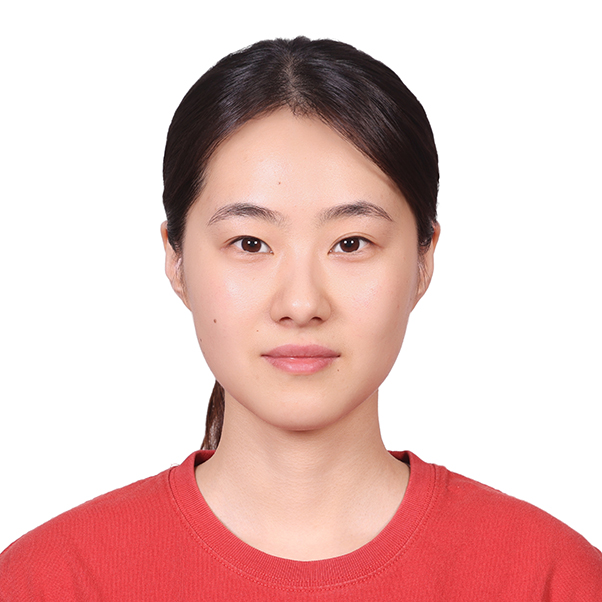 Headshot of a dark haired woman against a white background wearing a red shirt
