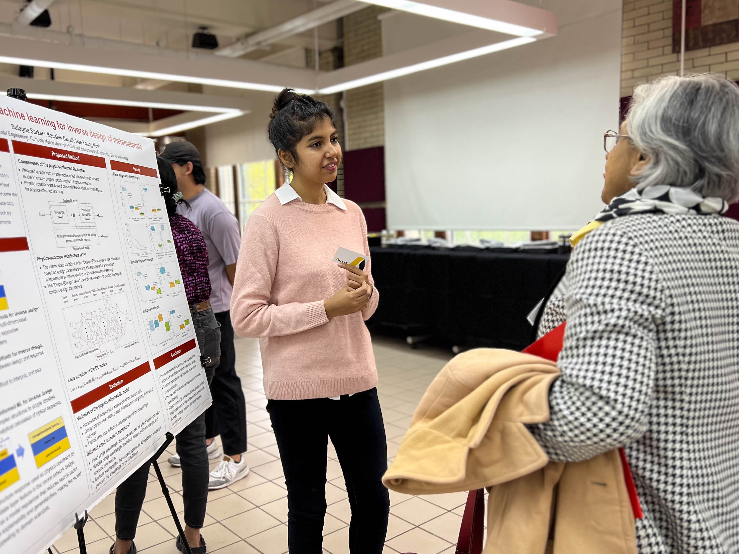 Student speaks with guest at poster session