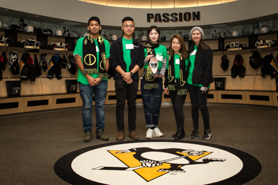 Green Team posing in Penguin's lockerroom with their trophy