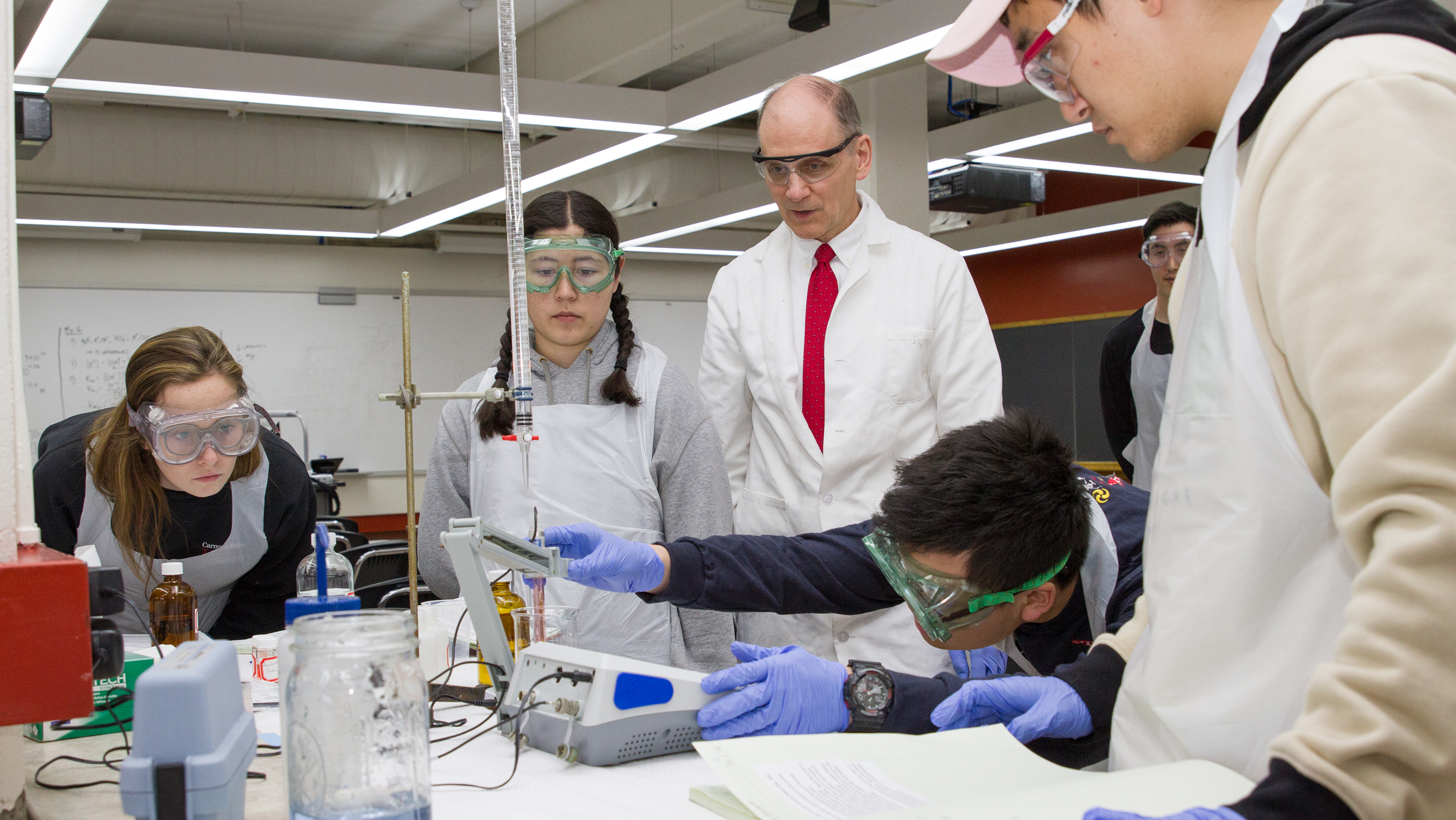 Students at lab bench conducting an experiment while Professor Dave Dzombak looks on