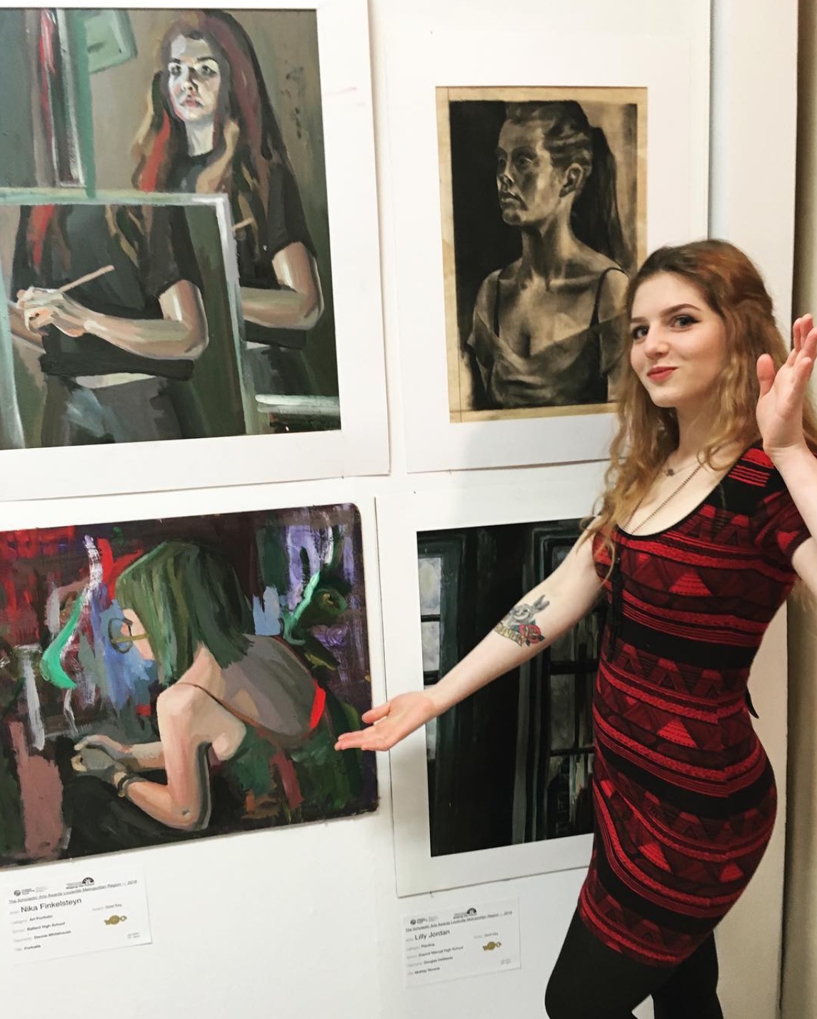 Nika posed in front of pieces in gallery show