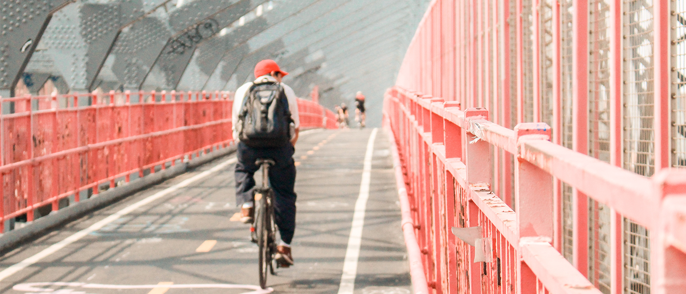 man on bike riding over a bridge