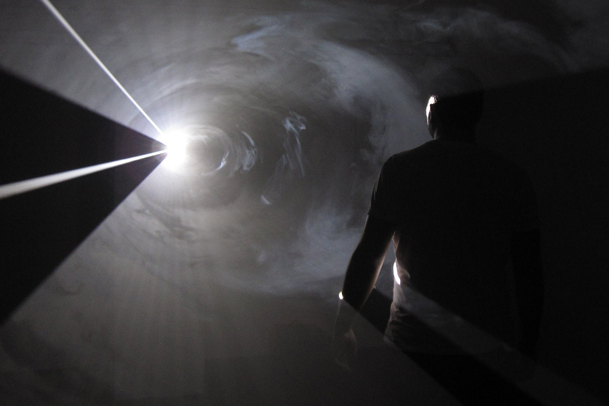 Photo from a 2010 wats:ON? Festival, black and white with a man surrounded by beams of light.