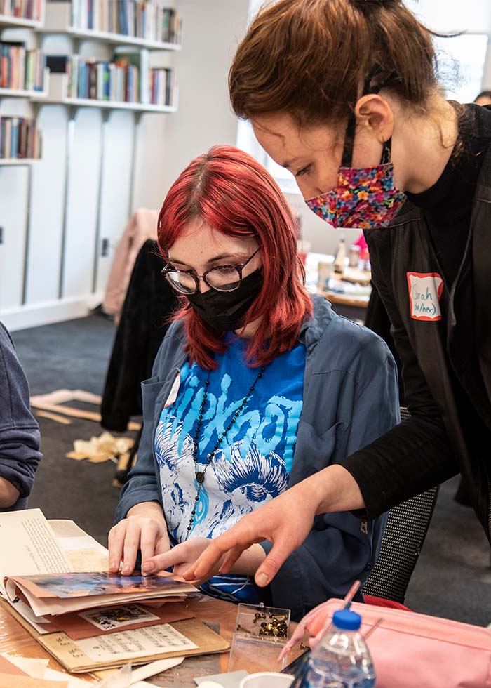 Ceurvorst talking with a student, as she shows her the book she bound by hand.