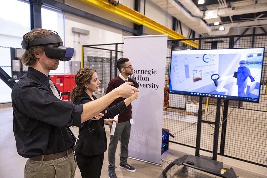 Azadeh Sawyer, center, assistant professor in building technology, gives a virtual reality tour at Mill 19 for green energy construction with the help of School of Architecture graduate students Mohammad Reza Takallouie, right, and Gavin Hurley, left.