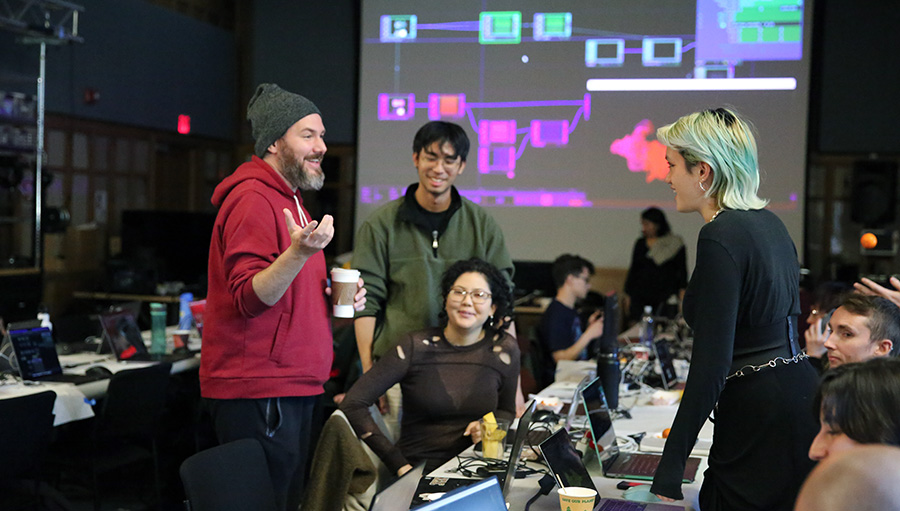 A group of people talking near laptops