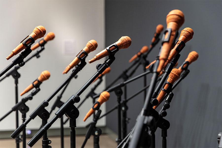 A group of copper-colored microphones in black stands