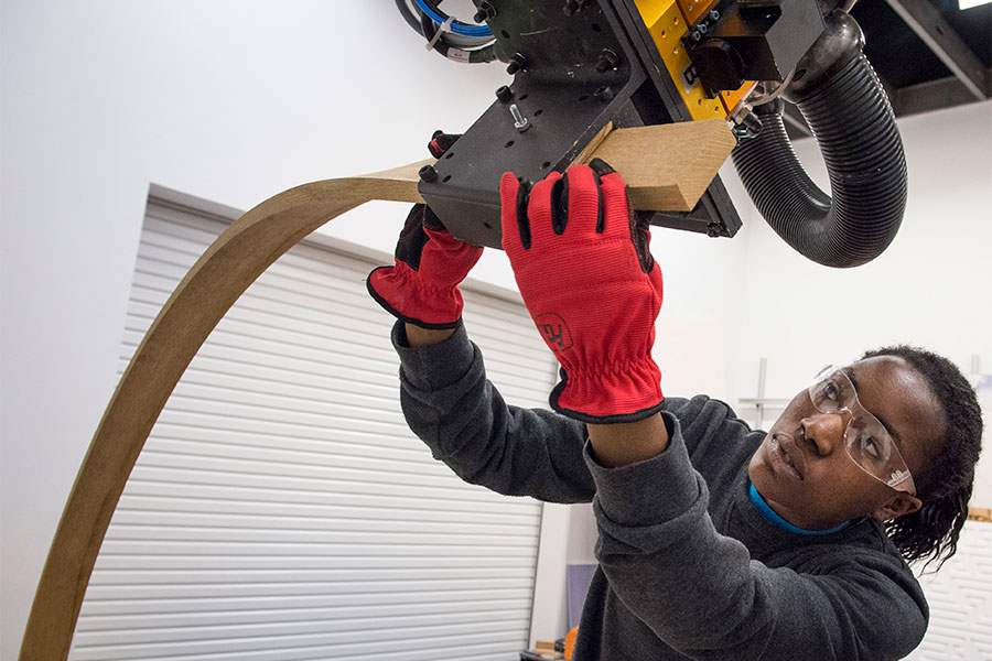 Photo of an undergraduate architecture student in dFAB with robot.