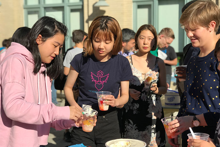 Photo of students at BXA Interdisciplinary social, treating themselves to punch.