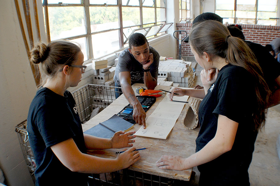 Architecture students huddled around a project.