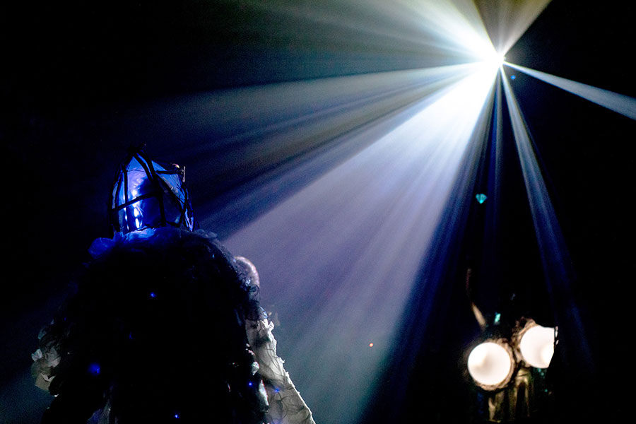 Photo of a figure in what appears to be dramatic stage lighting.
