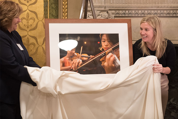 Photo of the unveiling of a photograph of CMU School of Music students, presented to Denis Colwell.