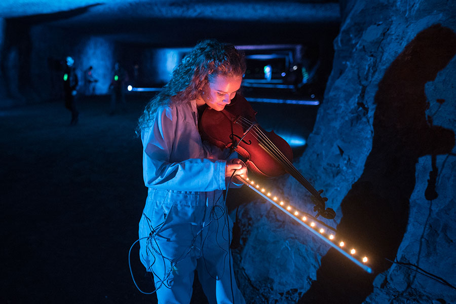 Student at the subsurface art and music festival with lights on her bow.