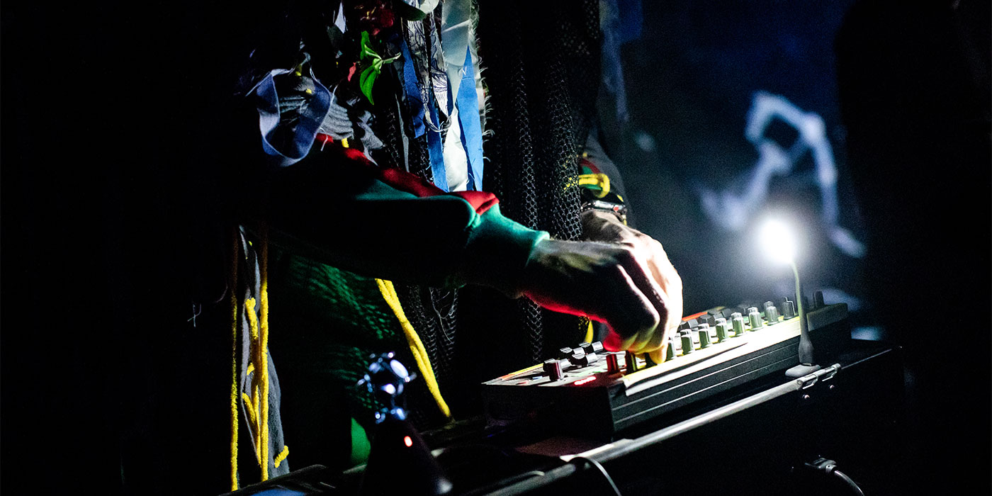 Man turning knobs, creating electronic music for the festival.