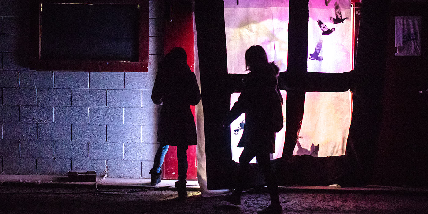 Students walking from the dark into the colorful lights of Subsurface.