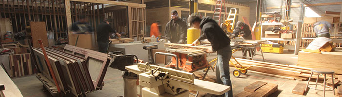 Photo of CMU Architecture and the Trade Institute of Pittsburgh sawing wood.