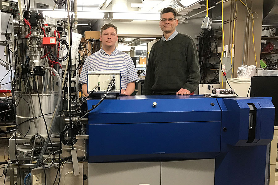 Logan Plath and Mark Bier with a mass spectrometer and its Superconducting Tunnel Junction cryodetector