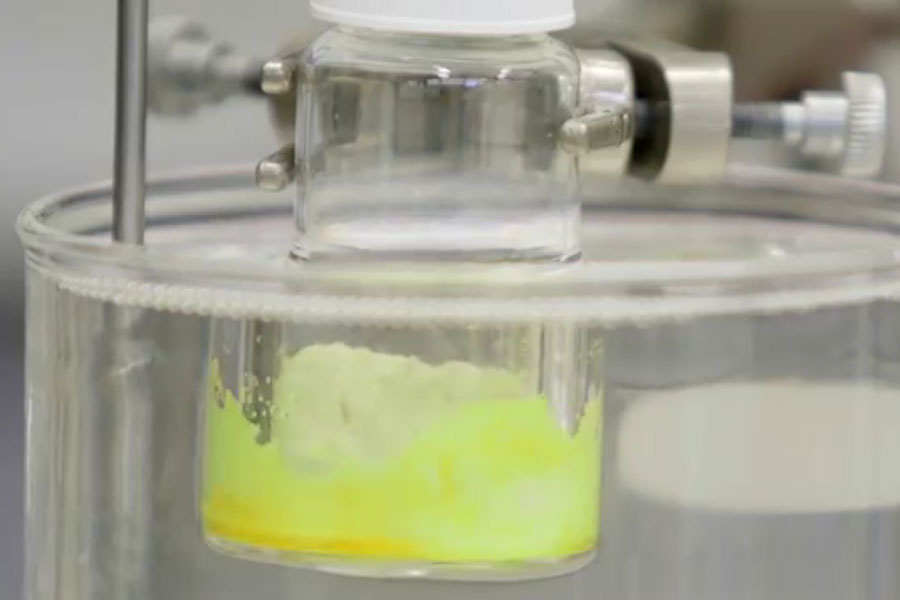 close-up of yellow substance in vial in laboratory