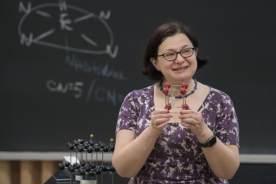 Catalina Achim in front of classroom holding a model of a molecule