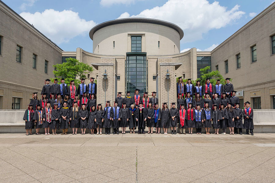 Phi Beta Kappa inductees in front of the Cohon University Center dressed in academic regalia
