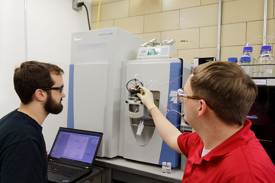 Graduate students collaborating in the CMA with mass spectrometer