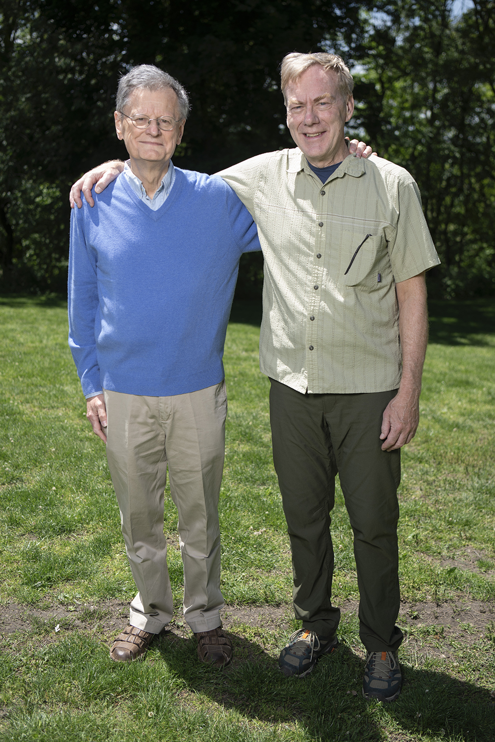 Emile Bominaar and Michael Hendrich stand outside with their arms around each other. They smile at the camera.