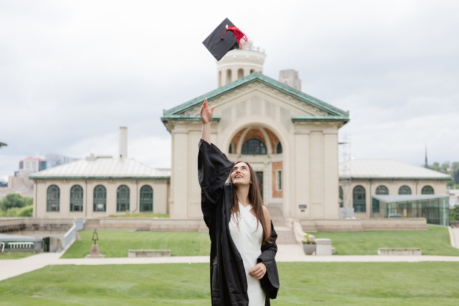 Aleksaundra Handrinos tossing her graduation cap in air, at CMU campus