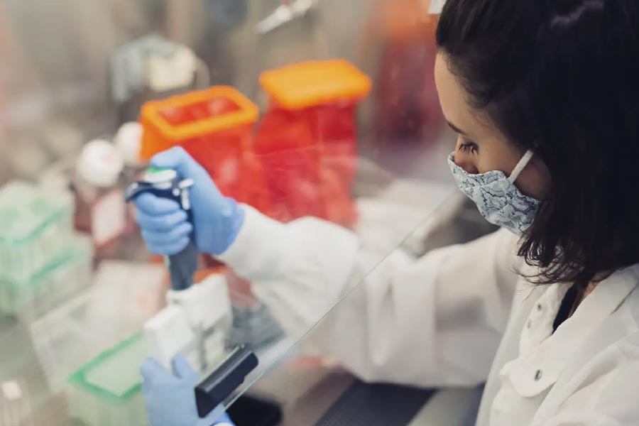Image of lab worker using electronic dropper device.