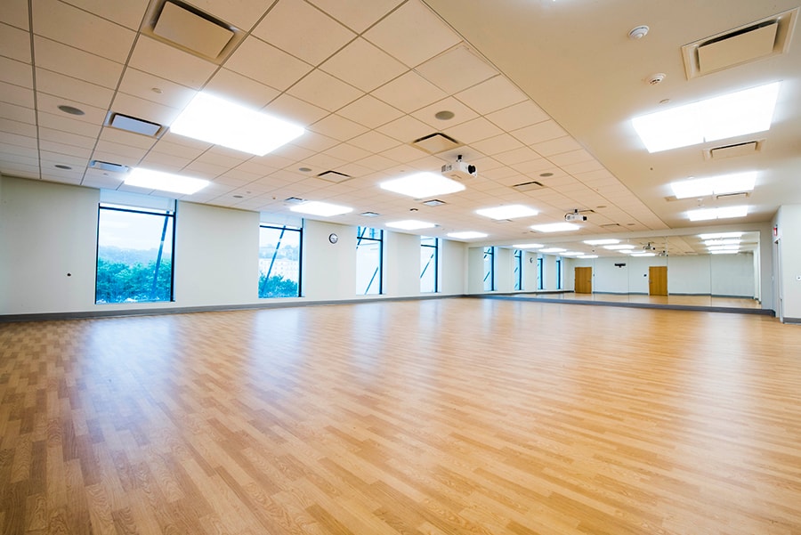 Photo of Askwith Kenner Exercise Studio on second floor, featuring mirrors, wood floors, projectors and large windows