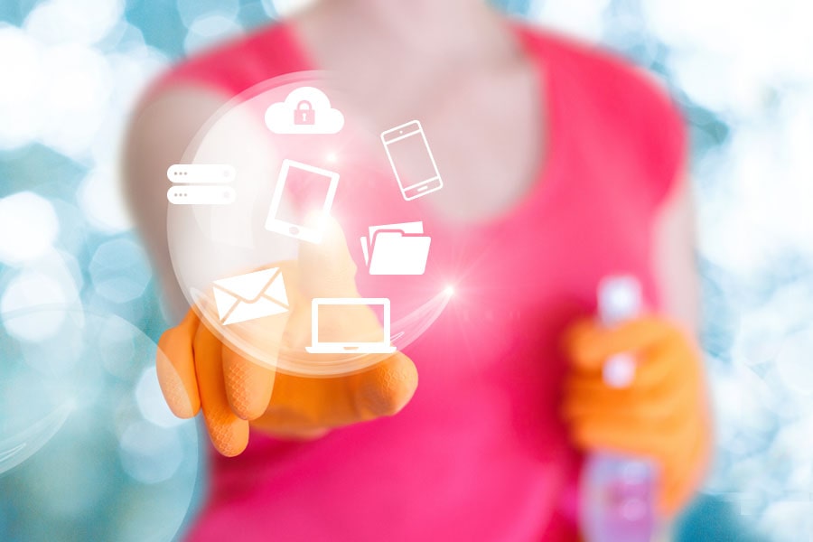 Image of woman with cleaning supplies touching a bubble with electronic devices.