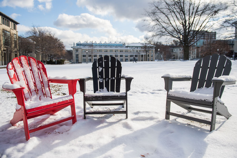 Photo of chairs covered in snow outside on the Cut on CMU's campus.