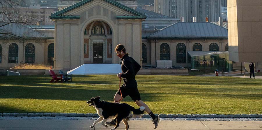 CMU student running on campus with dog in March 2021