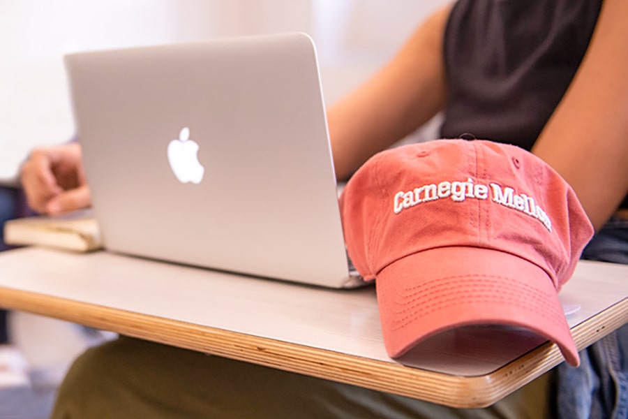 photo of student with laptop and cap