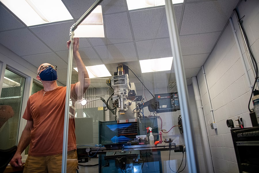 man holding a protective barrier around lab equipment