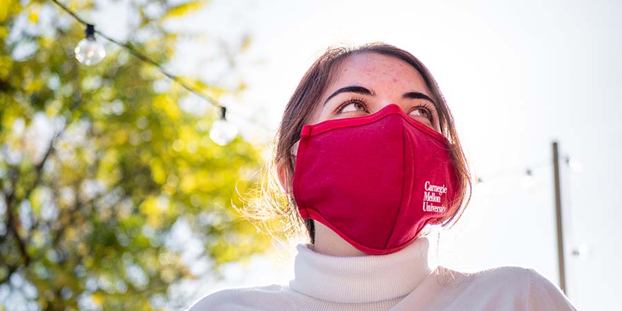 CMU student in turtleneck outside on campus wearing a mask