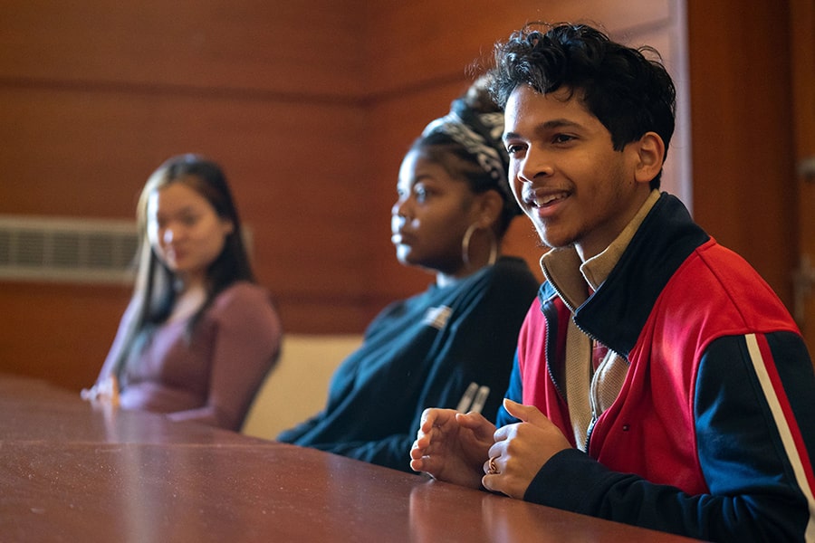 Students engage in a conversation at a round table discussion.