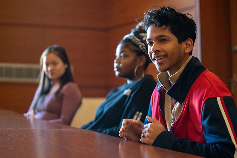 Students engage in a conversation at a round table discussion.