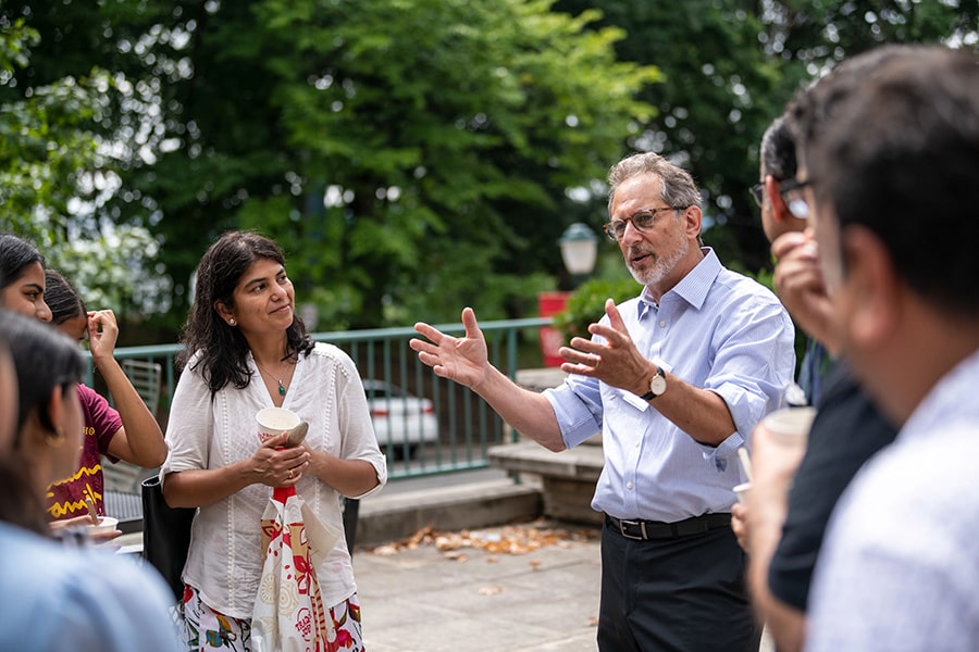 Dean Richard Scheines talks to alumni on an outdoor patio.