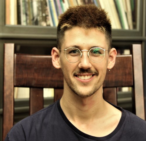 Wilson Ekern in front of bookshelf